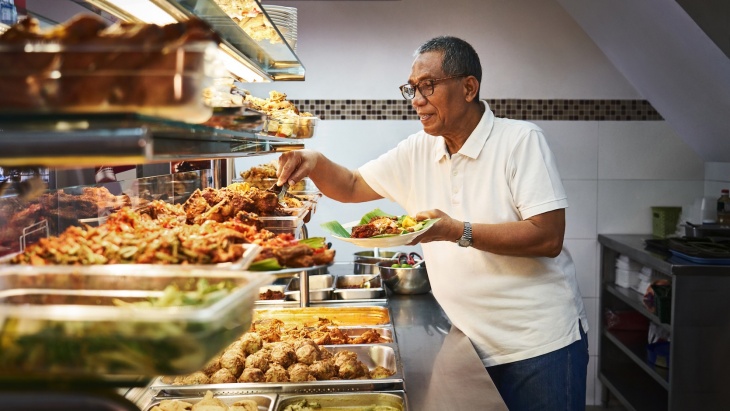 甘榜格南 Warong Nasi Pariaman Nasi Padang 的店(diàn)主正在準備食物(wù)