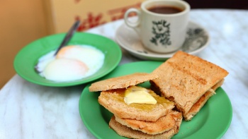 咖椰土司、半生熟蛋和一杯熱 kopi 的特寫鏡頭