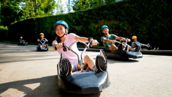 人們在斜坡滑車(chē) (Skyline Luge Sentosa) 玩卡丁車(chē)