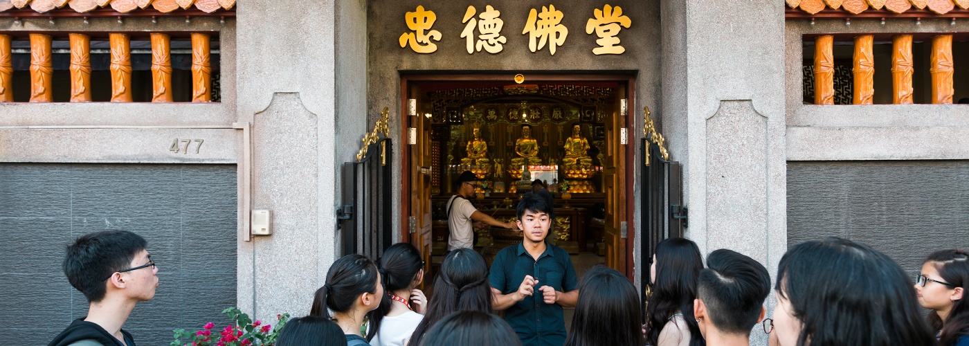 蔡引舟向遊客介紹一座佛教寺廟。